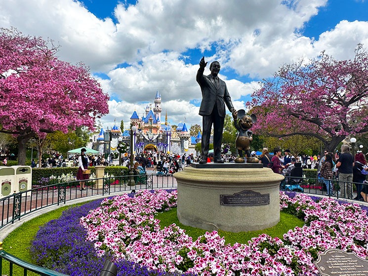 ディズニーランド・パークのセントラルプラザから撮影した「パートナーズ像（ウォルト＆ミッキー）」と、背景にそびえる眠れる森の美女の城