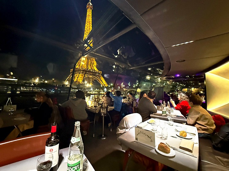 「バトーパリジャン」ディナークルーズの船内座席の様子とエッフェル塔の夜景