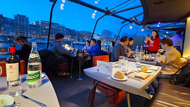 「バトーパリジャン」ディナークルーズの船内座席の様子とエッフェル塔の夜景